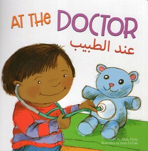 At the Doctor ( Arabic and English Edition ) (Board Book)